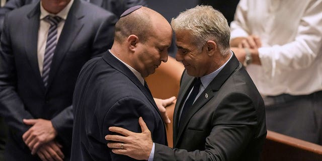 Israeli Prime Minister Naftali Bennett, left, and Foreign Minister Yair Lapid react after a vote on a bill to dissolve the parliament at the Knesset, Israel's parliament, in Jerusalem, Thursday, June 30, 2022. Israel's parliament has voted to dissolve itself, sending the country to the polls for the fifth time in less than four years. 