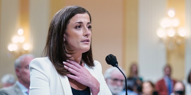 WASHINGTON, DC JUNE 28: Cassidy Hutchinson, a top aid to Mark Meadows when he was White House chief of staff in the Trump administration, gestures toward her neck as she retells a story involving President Trump as the House Jan. 6 select committee holds a public hearing on Capitol Hill on Tuesday, June 28, 2022. 