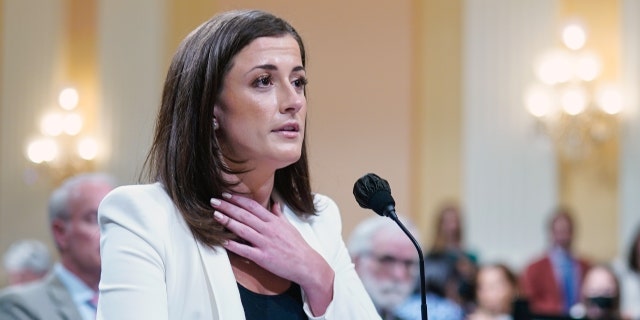 WASHINGTON, DC JUNE 28: Cassidy Hutchinson, a top aide to Mark Meadows when he was White House chief of staff in the Trump administration, gestures toward her neck as she retells a story involving President Trump as the House Jan. 6 select committee holds a public hearing on Capitol Hill on Tuesday, June 28, 2022. 