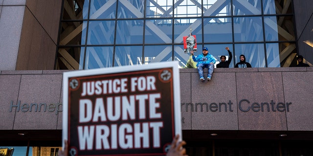 Damik Wright (C),  Emajay Driver (R) and Dallas Bryant (2nd R),brothers of Daunte Wright wait for the verdict in Kim Potter's trial over the death of Daunte Wright outside the Hennepin County Courthouse in Minneapolis, Minnesota on December 23, 2021. 