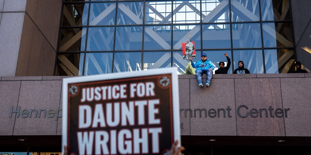 Damik Wright (C),  Emajay Driver (R) and Dallas Bryant (2nd R),brothers of Daunte Wright wait for the verdict in Kim Potter's trial over the death of Daunte Wright outside the Hennepin County Courthouse in Minneapolis, Minnesota on December 23, 2021. 