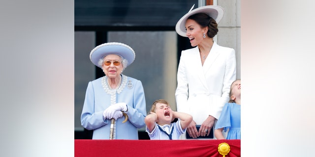 Queen Elizabeth II, Prince Louis of Cambridge and Catherine, Duchess of Cambridge watch a flypast from the balcony of Buckingham Palace during Trooping the Colour on June 2, 2022, in London, England.