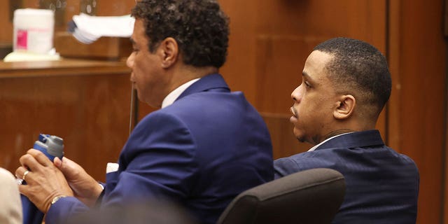 Defendant Eric Holder Jr., right, and his attorney Aaron Jansen appear at trial.