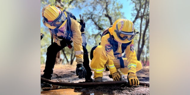 A camper learns how to clamp a fire hose during training exercises at Camp Cinder in Redding, 칼리프.