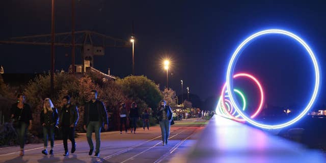 Youths walk on quay Des Anneaux near the Warehouse nightclub, Wednesday, May 18, 2022, in Nantes, western France.