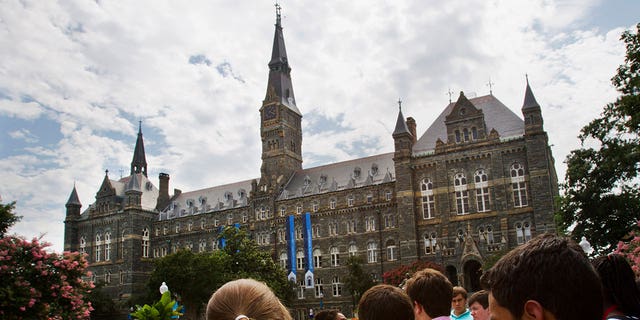 Prospective students tour Georgetown University's campus, on July 10, 2013, in Washington. Amin Khoury is scheduled to stand trial Tuesday June 7, 2022, in Boston, on charges that he bribed Georgetown University tennis coach Gordon Ernst to get his daughter into the school as a recruit. (AP Photo/Jacquelyn Martin, File)