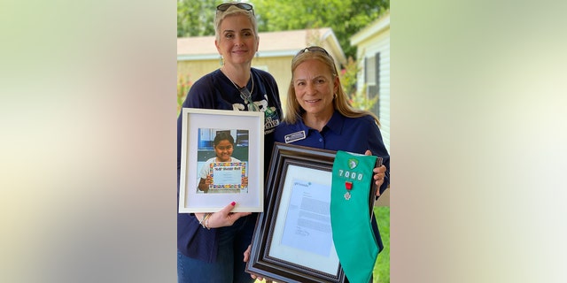 Jody Hernandez, chief operating officer, and Angela Salinas, Major General, U.S. Marine Corps (Ret.), chief executive officer, of Girl Scouts of Southwest Texas hold up a letter from Girl Scouts of the USA and a photo of Uvalde shooting victim Amerie Jo Garza, May 27, 2022. (Girl Scouts of Southwest Texas / Magnifi U / TMX)