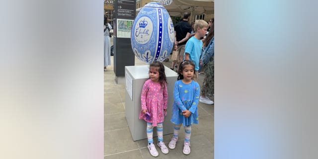 Two toddlers engage in Platinum Jubilee festivities with themed face paint. 