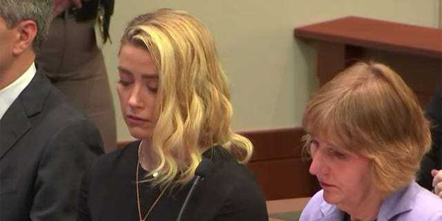 Amber Heard listening to the jury verdict in her ex-husband's defamation claim against her.