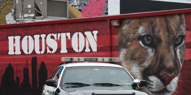 A Houston police car in front of a graffiti-covered building in the Old Chinatown section of downtown near the George R. Brown Convention Center.