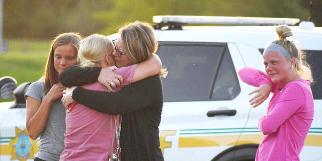 People console each other after a shooting outside Cornerstone Church in Ames, Iowa, June 2, 2022.