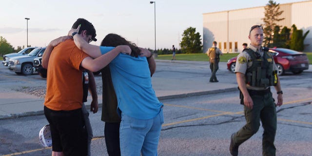 People pray at the CrossRoad Baptist Church parking lot after a shooting at Cornerstone Church in Ames, Iowa, June 2, 2022.