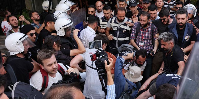 Polizeibeamte hindern Journalisten daran, inhaftierte Aktivisten zu filmen und zu fotografieren, als sie versuchen, auf eine von den örtlichen Behörden verbotene Pride-Kundgebung im Zentrum von Istanbul, Türkei, zu marschieren, 26. Juni 2022 (Reuters/Umit Bektas)