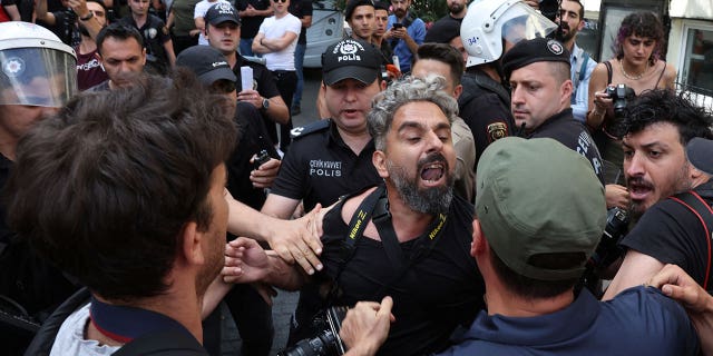 Polizeibeamte hindern Journalisten daran, inhaftierte Aktivisten zu filmen und zu fotografieren, als sie versuchen, auf eine von den örtlichen Behörden verbotene Pride-Kundgebung im Zentrum von Istanbul, Türkei, zu marschieren, 26. Juni 2022 (Reuters/Umit Bektas)