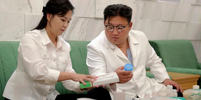 In this photo provided by the North Korean government, North Korean leader Kim Jong Un and his wife Ri Sol Ju prepare medicine at an undisclosed location in North Korea on Wednesday, June 15, 2022, to send to the city of Haeju where an infectious disease occurred.