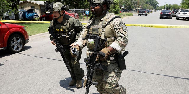 Law enforcement personnel run away from the scene of a suspected shooting near Robb Elementary School in Uvalde, Texas, U.S. May 24, 2022.