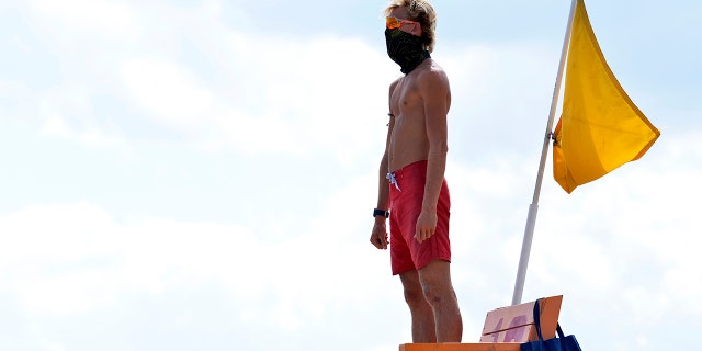 A lifeguard wearing a face covering surveys the water at Hampton Beach in Hampton, New Hampshire, on August 5, 2020. (JOSEPH PREZIOSO/AFP via Getty Images)