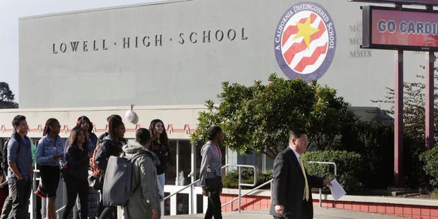 Lowell High School principal Andrew Ishibashi (right) walks across Eucalyptus Drive along with some students and staff to make a statement to the media regarding a poster that referred negatively to black students and Black History Month on Tuesday, February 23, 2016 in San Francisco, California. 