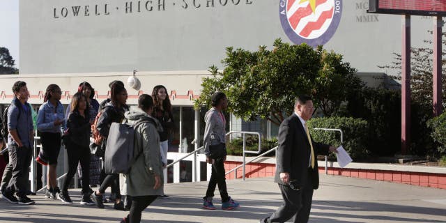 Lowell High School principal Andrew Ishibashi (right) walks across Eucalyptus Drive along with some students and staff to make a statement to the media regarding a poster that referred negatively to black students and Black History Month on Tuesday, February 23, 2016 in San Francisco, California.