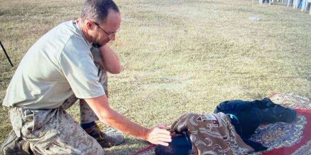 Mal James with a child while on assignment.