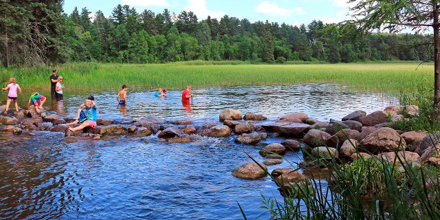 Children play in the outlet of Lake Itasca Minnesota.