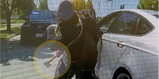 This still from body-worn camera footage shows a man wielding a hatchet charging at a police officer in the Chicago suburb of Naperville, Illinois.