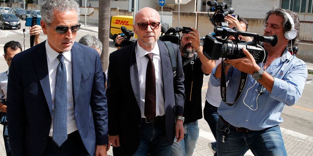 Canadian-born film director Paul Haggis, center, arrives with his lawyer Michele Laforgia at Brindisi law court in southern Italy, Wednesday, June 22, 2022, to be heard by prosecutors investigating a woman's allegations he had sex with her without her consent over the course of two days. Under Italian law, a judge, after hearing arguments from both prosecutors and defense lawyers, will rule on whether Haggis can be set free pending possible additional investigation. (AP Photo/Salvatore Laporta)