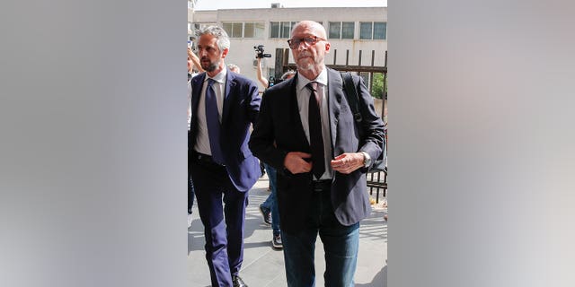 Canadian-born film director Paul Haggis, right, arrives with his lawyer Federico Straziota at Brindisi law court in southern Italy, Wednesday, June 22, 2022, to be heard by prosecutors investigating a woman's allegations he had sex with her without her consent over the course of two days. Under Italian law, a judge, after hearing arguments from both prosecutors and defense lawyers, will rule on whether Haggis can be set free pending possible additional investigation. (AP Photo/Salvatore Laporta)