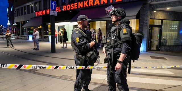 Police stand guard outside a bar in central Oslo, early Saturday, June 25, 2022. Norwegian police say a two people were killed and at at least 10 were injured.