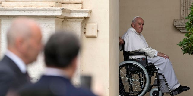Pope Francis arrives on a wheelchair for an audience with children in the San Damaso courtyard at the Vatican Saturday, June 4, 2022. Pope Francis added fuel to rumors about the future of his pontificate Saturday by announcing he would visit the central Italian city of L'Aquila in August for a feast initiated by Pope Celestine V, one of the few pontiffs who resigned before Pope Benedict XVI stepped down in 2013.