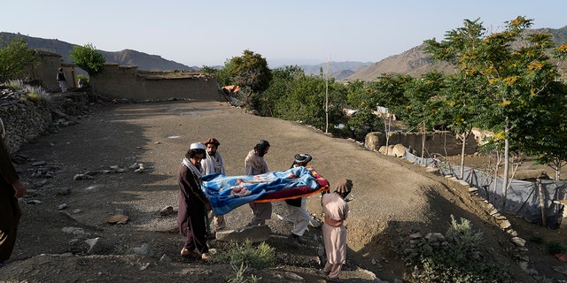 Afghans carry a relative killed in an earthquake to a burial site l in Gayan village, in Paktika province, Afghanistan, Thursday, June 23, 2022.