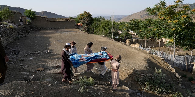 Afghans carry a relative killed in an earthquake to a burial site l in Gayan village, in Paktika province, Afghanistan, Thursday, June 23, 2022.