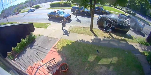 The suspects are seen climbing out of a smashed windshield of the SUV, which was on its side, and appear to attempt to flee on foot before they were apprehended by the officers.