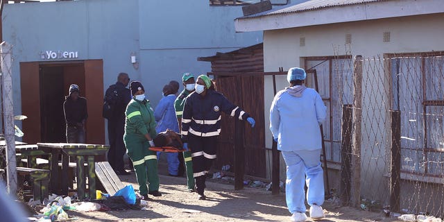 A body is removed from a nightclub in East London, South Africa, Sunday June 26, 2022. South African police are investigating the deaths of at least 20 people at a nightclub in the coastal town of East London early Sunday morning. It is unclear what led to the deaths of the young people, who were reportedly attending a party to celebrate the end of winter school exams.