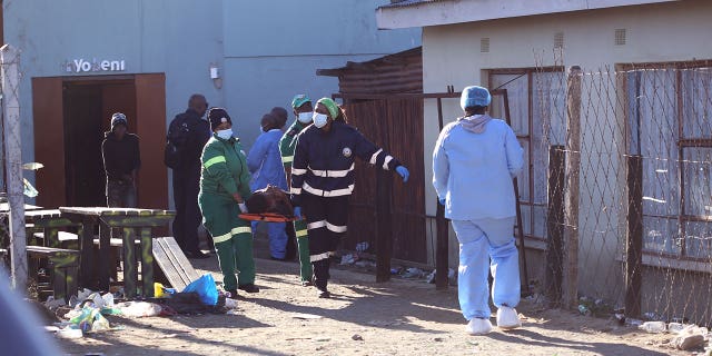 A body is removed from a nightclub in East London, South Africa, Sunday June 26, 2022. South African police are investigating the deaths of at least 20 people at a nightclub in the coastal town of East London early Sunday morning. It is unclear what led to the deaths of the young people, who were reportedly attending a party to celebrate the end of winter school exams.