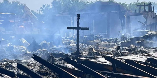 A cross still stands after a fire destroyed the Balsora Baptist Church in Bridgeport, Texas, on Friday.