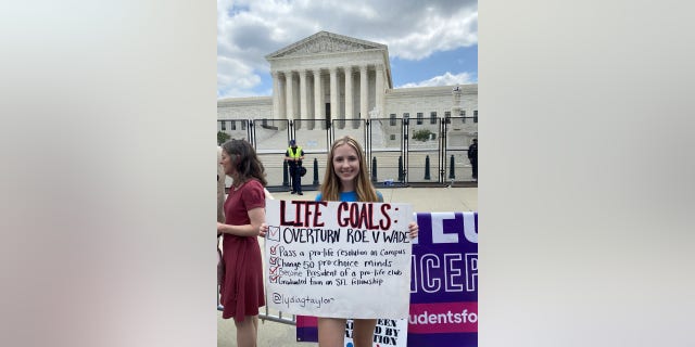 A woman holds a sign celebrating the Supreme Court's ruling to overturn Roe vs. Wade.