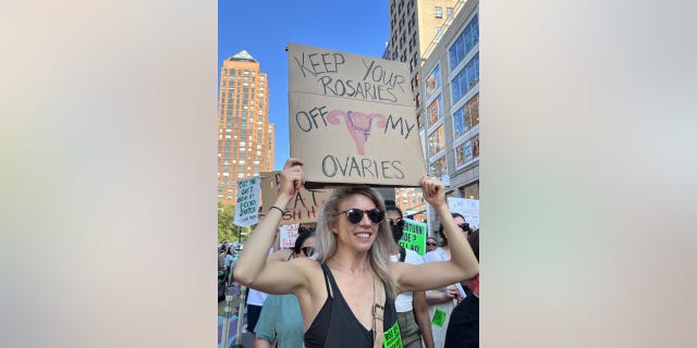 A woman holds a sign reading, "Keep Your Rosaries Off my Ovaries" after the Supreme Court ruled to overturn Roe vs. Wade.
