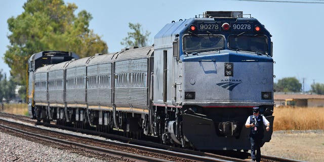 An Amtrak train conductor walks towards the scene of the accident after colliding with a vehicle in Brentwood, Calif., on Sunday, June 26, 2022. (Jose Carlos Fajardo/Bay Area News Group via AP)