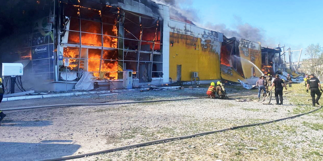 Rescuers work to extinguish a fire in a shopping center.
