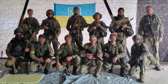 A U.S. Army veteran poses for a group photo with members of the Ukrainian Territorial Defense force.