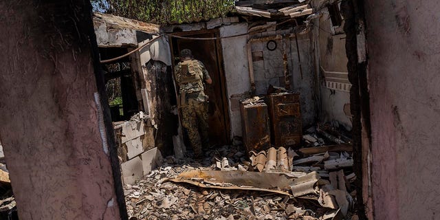 2022 年 6 月 2 日，星期四，乌克兰东部顿涅茨克州地区前线附近的一个村庄，乌克兰军队炮兵部队指挥官米哈伊洛·斯特雷比兹 (Mykhailo Strebizh) 走进一座被毁坏的房屋。 