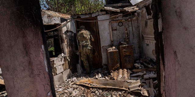 Commander of an artillery unit of the Ukrainian army, Mykhailo Strebizh walks into a destroyed house due to shelling in a village near the frontline in the Donetsk oblast region, este de Ucrania, jueves, junio 2, 2022.