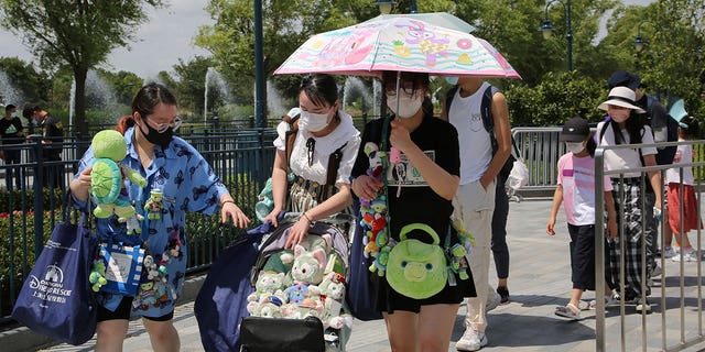 Visitors line up outside the Disney Resort theme park, Thursday, June 30, 2022, in Shanghai. Shanghai is moving to allow in-person dining and reopening its Disney Resort theme park as domestically transmitted cases of COVID-19 in China's largest city remain at zero following a more than two-month lockdown. 