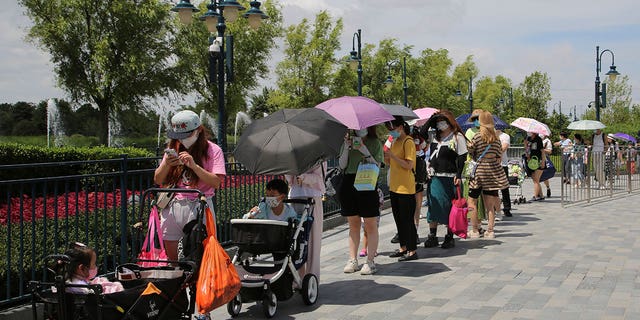 Visitors line up outside the Disney Resort theme park, Thursday, June 30, 2022, in Shanghai. Shanghai is moving to allow in-person dining and reopening its Disney Resort theme park as domestically transmitted cases of COVID-19 in China's largest city remain at zero following a more than two-month lockdown. 