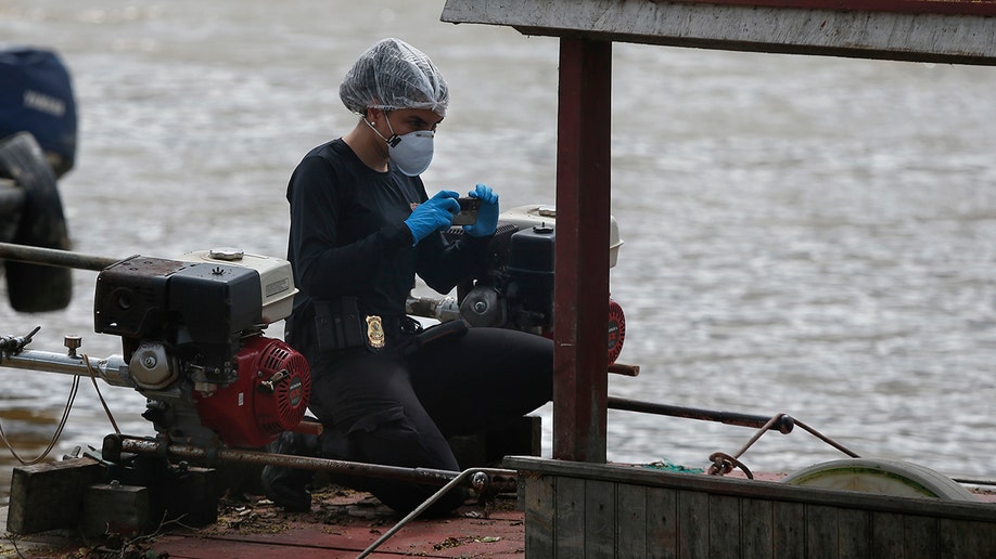 Brazil police investigator takes picture of seized boat