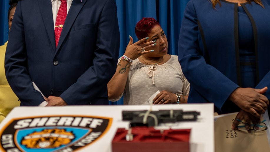Yanely Henriquez, the mother of young shooting victim Angellyh Yambo, wipes away tears 