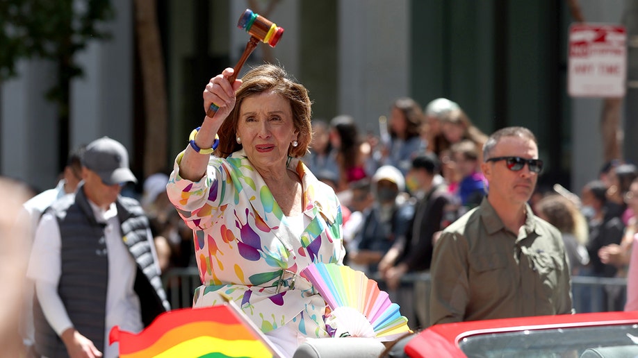 Nancy Pelosi at pride parade with rainbow gavel