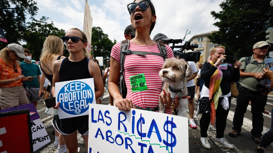 Two woman hold pro-choice signs