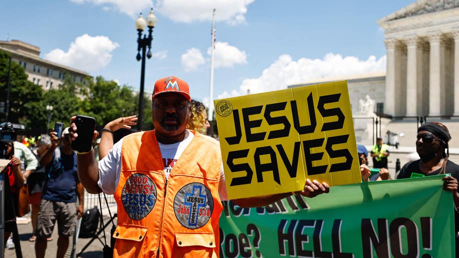 Man holds 'Jesus Saves' sign